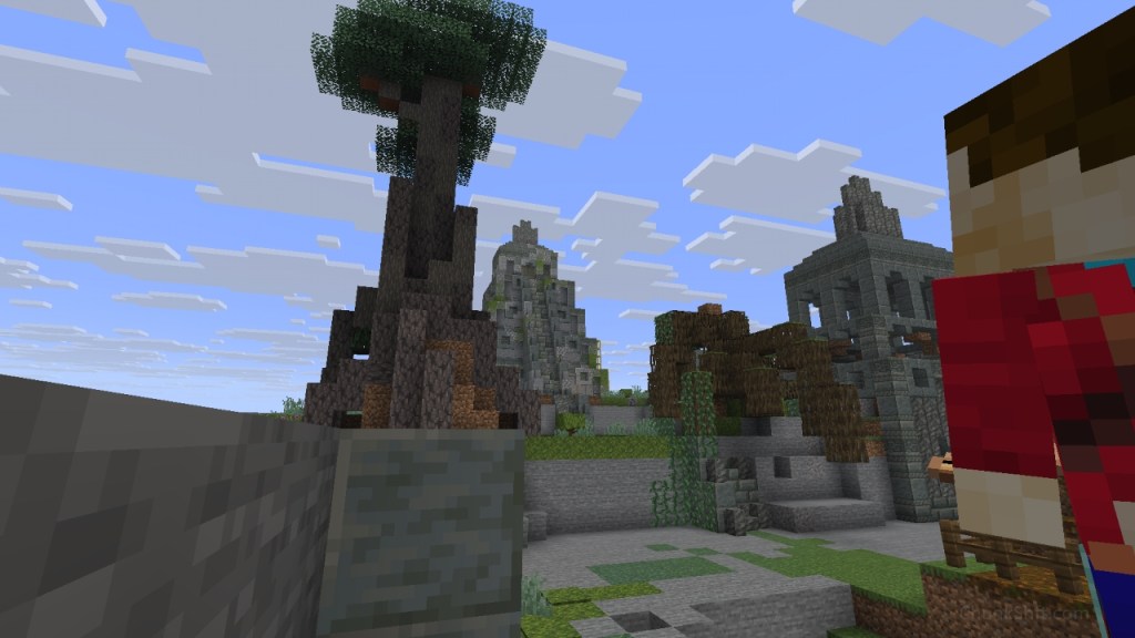 The player, flanked by polished tuff, looks at a mayan style pyramid in the distance. Framed by a tree on one side and another temple type structure. The area is clearly unfinished with exposed stone from player manipulation of the landscape.