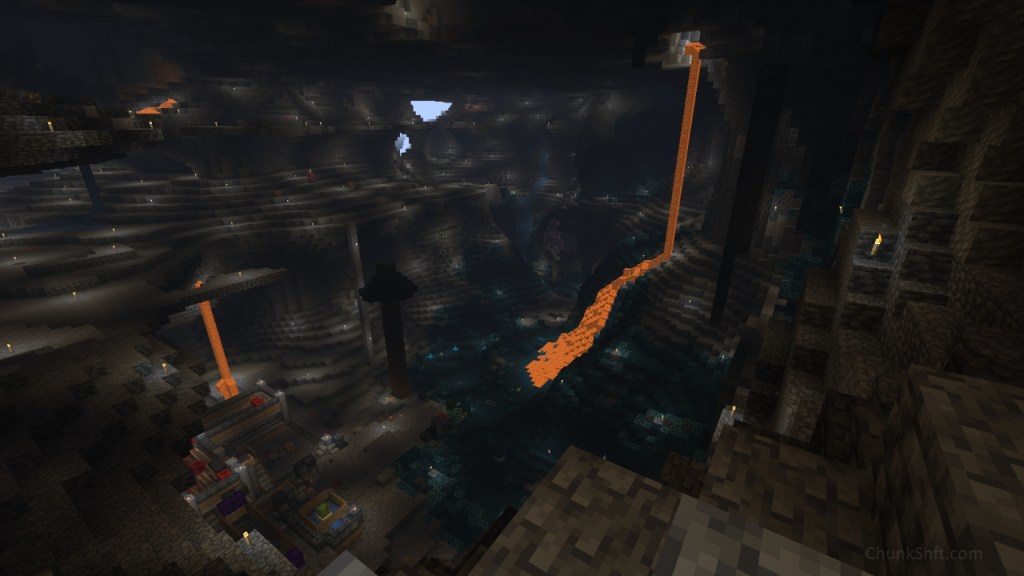 Lava falls from the ceiling and cascades over a hill of skulk. The cavern of the techno-cave fully in view. Torches dot the floors of the cavern and some redstone contraptions can be seen on the cavern floor.