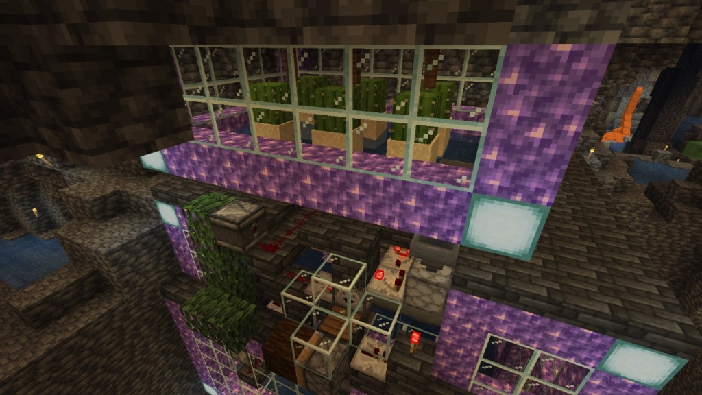Sections of glass are framed with blocks of amethyst and sea lanterns are at each corner. Top of the image is a small cactus farm. Below the redstone clock slightly set into the side of the encased farm.