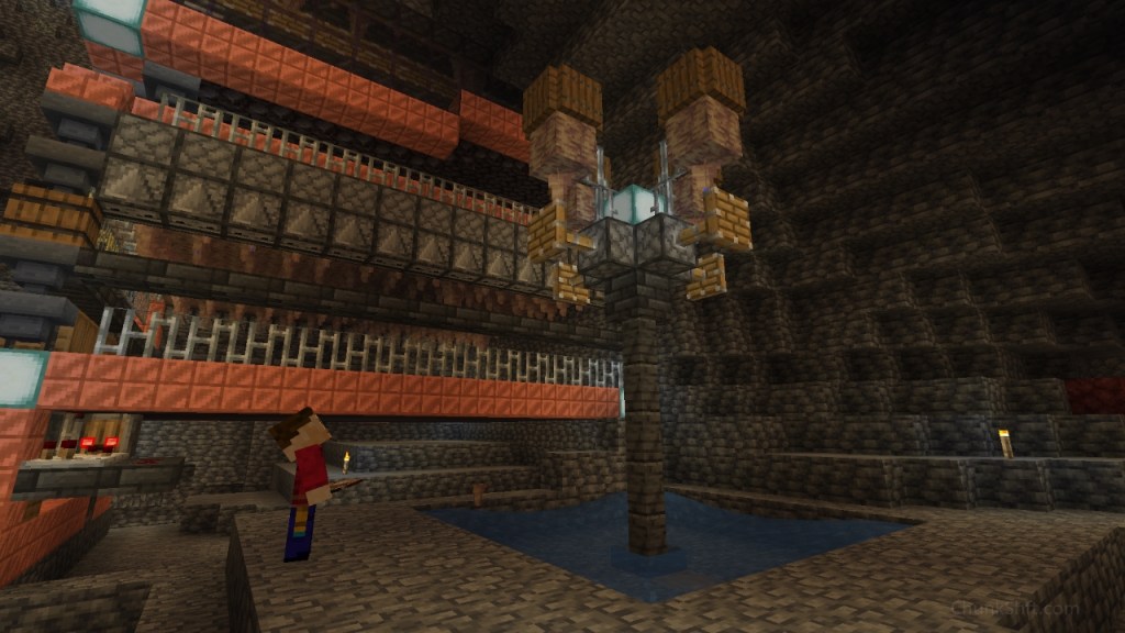 The player looks up at 4 extended pistons blocking growth of pointed dripstone. The larger farm is visible in the background. Water funnels blocks from the farm into the base.